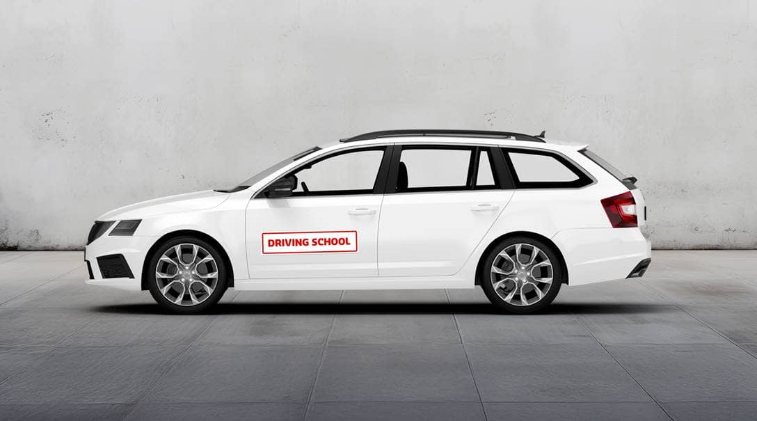 Ein weißes Auto, auf dem eine beschriftete Magnetfolie angebracht ist.