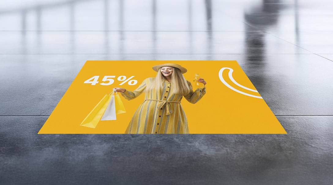 Ein hellgelber Aufkleber mit einer Frau abgebildet, der auf dem Fußboden klebt.